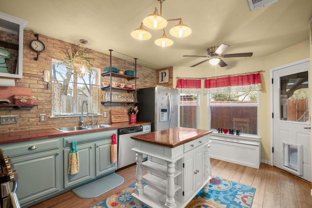 kitchen with wood counters, sink, light hardwood / wood-style flooring, and appliances with stainless steel finishes