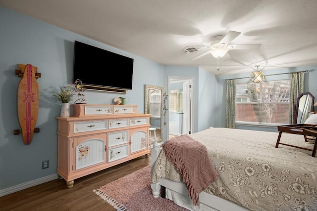 bedroom with ceiling fan, dark wood-type flooring, and ensuite bath