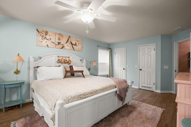 bedroom featuring ceiling fan, dark hardwood / wood-style floors, and multiple closets