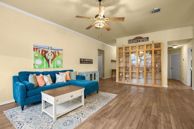 living room with ornamental molding, hardwood / wood-style floors, and ceiling fan