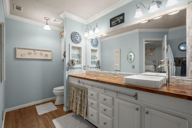 bathroom featuring ornamental molding, hardwood / wood-style floors, vanity, and toilet