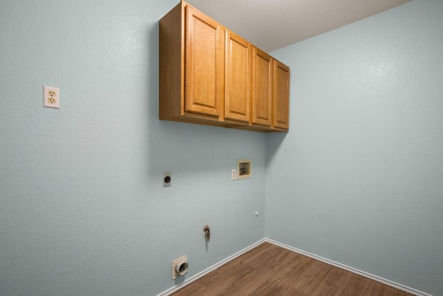 clothes washing area featuring cabinets, hardwood / wood-style flooring, hookup for a gas dryer, hookup for a washing machine, and hookup for an electric dryer