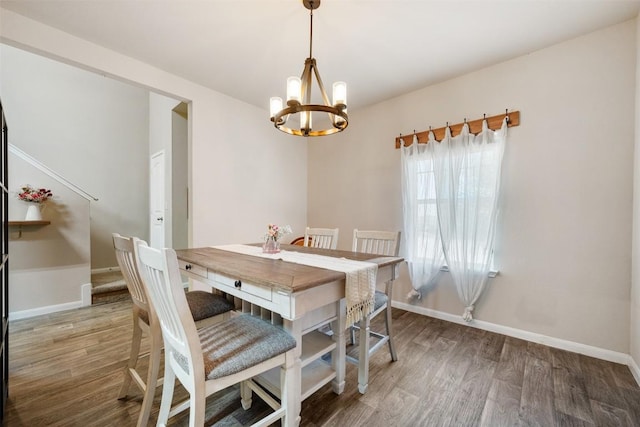 dining space with a chandelier and dark hardwood / wood-style flooring