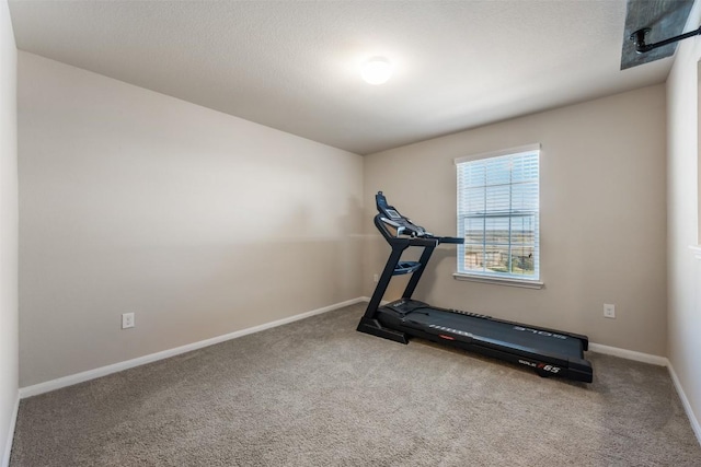 exercise area featuring carpet flooring and a textured ceiling