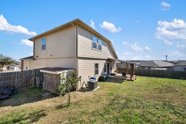 rear view of house featuring cooling unit, a patio area, and a lawn