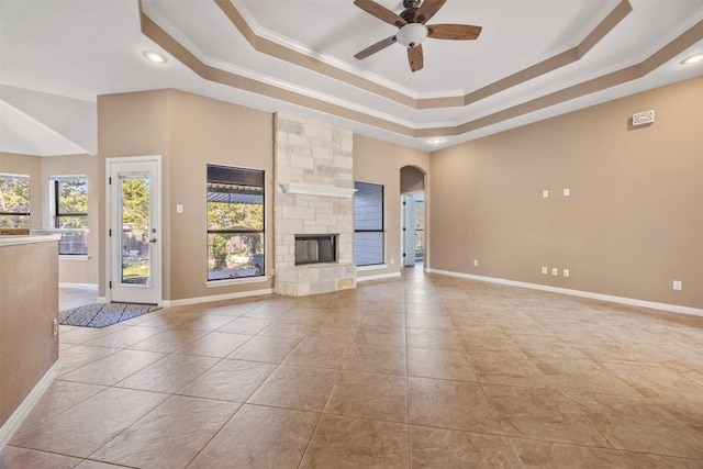 unfurnished living room with a raised ceiling, crown molding, light tile patterned floors, and a fireplace