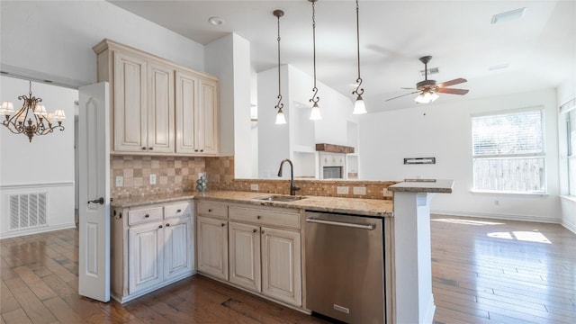 kitchen with decorative light fixtures, tasteful backsplash, sink, stainless steel dishwasher, and light stone countertops