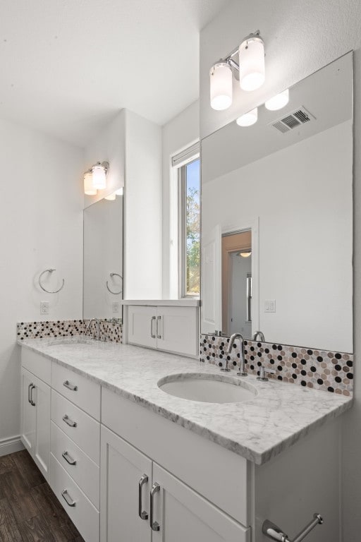 bathroom with decorative backsplash, wood-type flooring, and vanity