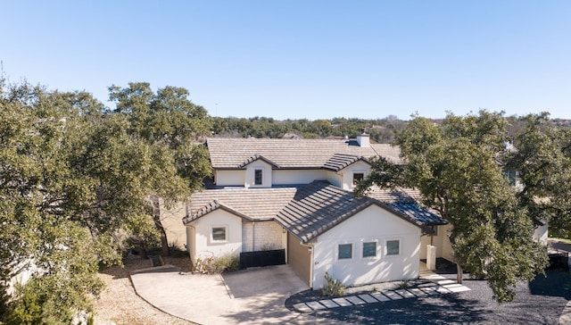5 Crystal Springs Ct Unit A, The Hills, TX 78738 - view of front of property with a tiled roof, stucco siding, driveway, and a chimney