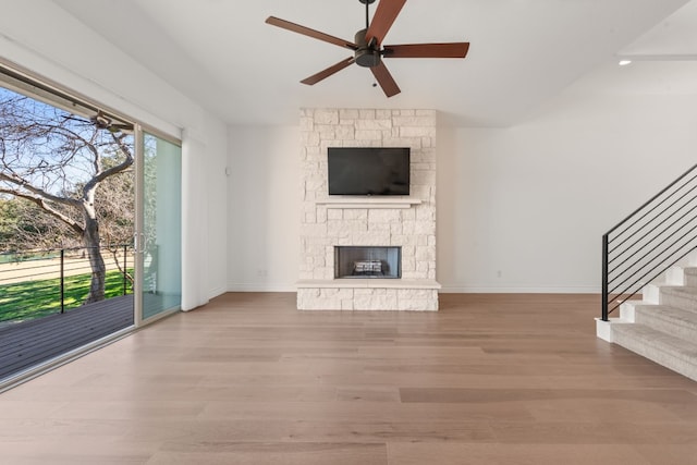 unfurnished living room featuring light hardwood / wood-style flooring, a fireplace, and ceiling fan