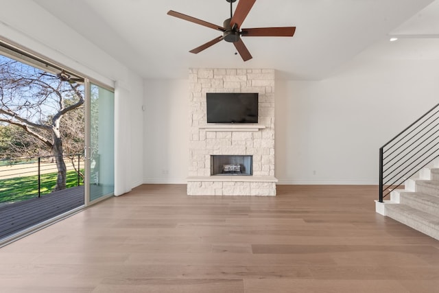 5 Crystal Springs Ct Unit A, The Hills, TX 78738 - unfurnished living room with ceiling fan, wood finished floors, stairs, baseboards, and a stone fireplace