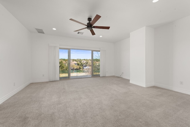 spare room with ceiling fan and light carpet