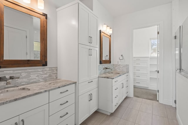 bathroom featuring tile patterned flooring, vanity, and decorative backsplash