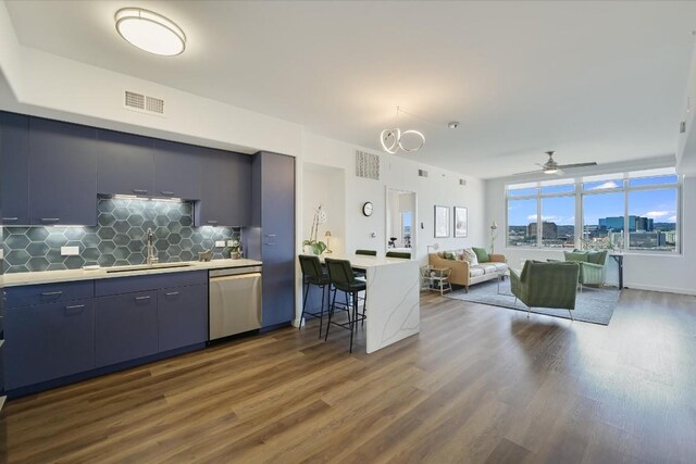 kitchen with stainless steel dishwasher, dark hardwood / wood-style floors, sink, and decorative backsplash