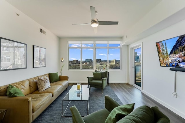 living room featuring dark wood-type flooring and ceiling fan