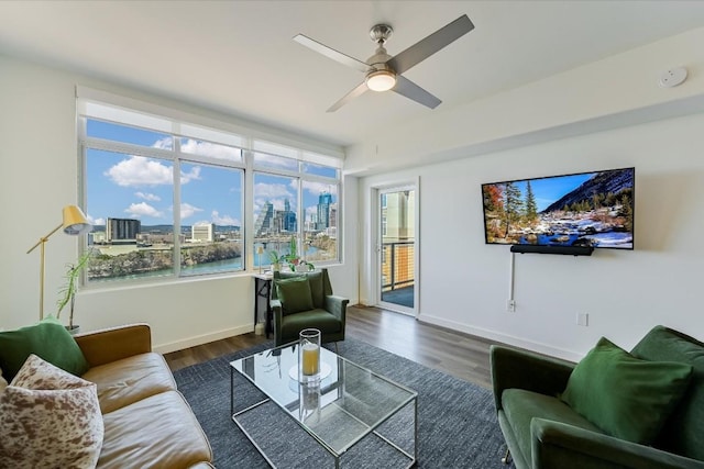 living room with dark wood-type flooring and ceiling fan