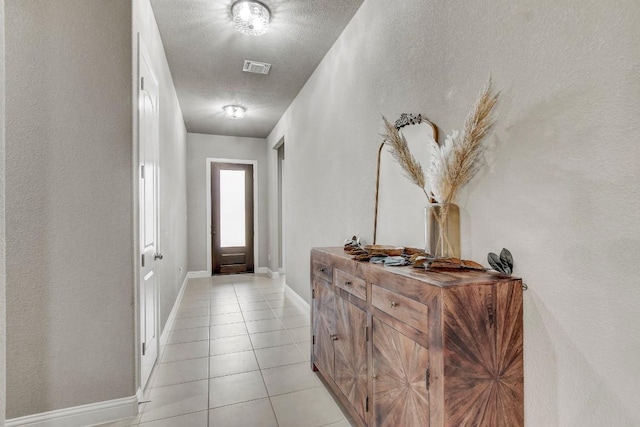 entryway with a textured ceiling and light tile patterned flooring