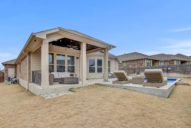 rear view of house with ceiling fan, a yard, an outdoor hangout area, and a patio