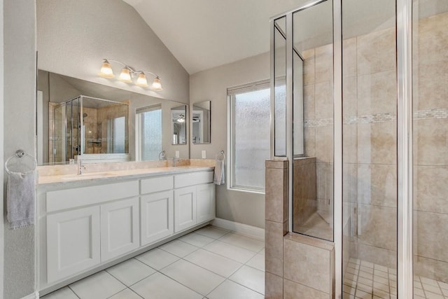 bathroom featuring vanity, vaulted ceiling, tile patterned floors, and walk in shower