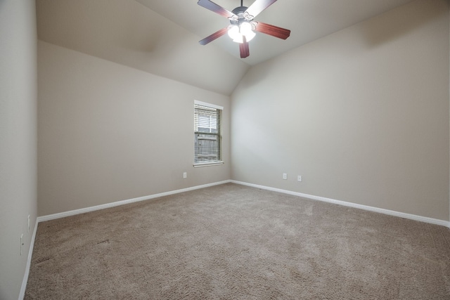 empty room with vaulted ceiling, ceiling fan, and carpet