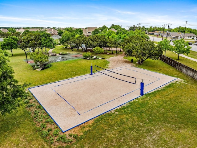 view of property's community with a lawn and volleyball court