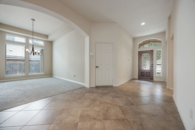 carpeted entryway with an inviting chandelier and a towering ceiling