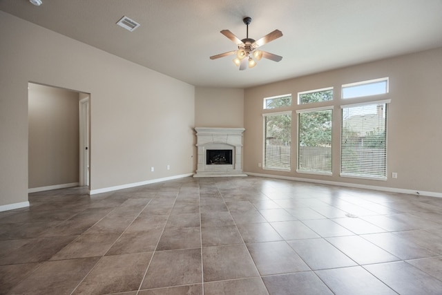 unfurnished living room featuring light tile patterned floors, a fireplace, and ceiling fan