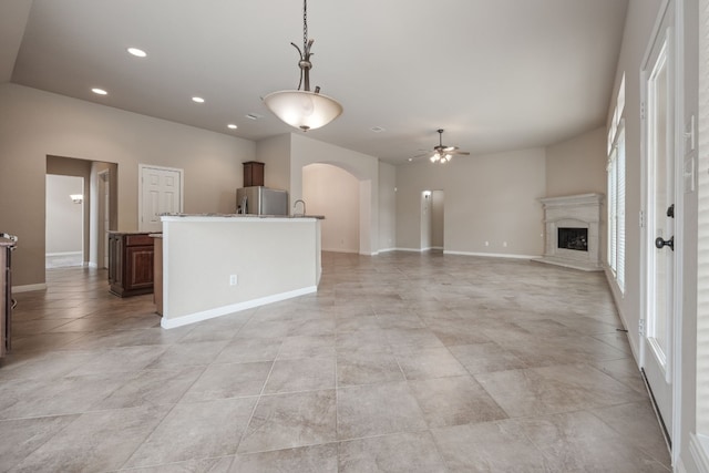 unfurnished living room with light tile patterned floors and ceiling fan