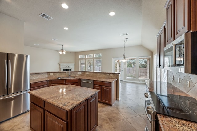 kitchen featuring pendant lighting, sink, a center island, and appliances with stainless steel finishes