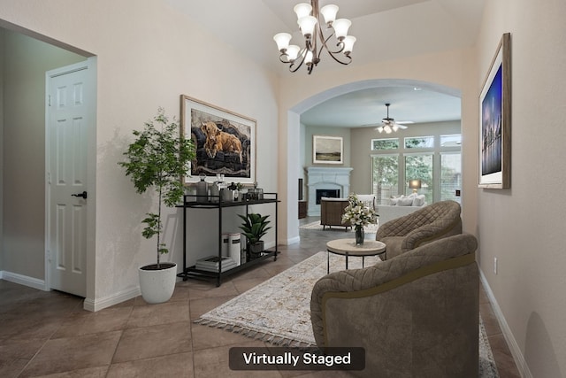 living room with light tile patterned flooring and ceiling fan with notable chandelier