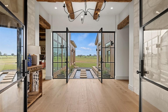 entryway featuring a notable chandelier, light wood-type flooring, and french doors