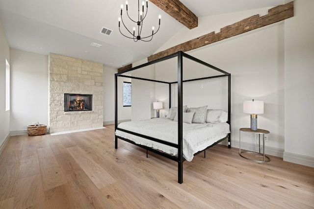 1318 Country Side Bnd, Fredericksburg, TX 78624 - bedroom with wood finished floors, baseboards, a chandelier, and a stone fireplace
