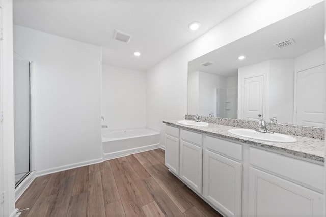 bathroom with wood-type flooring, separate shower and tub, and vanity