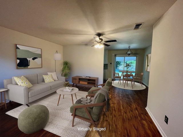 living room featuring dark hardwood / wood-style floors and ceiling fan