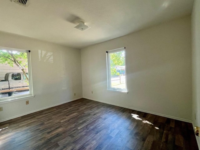 empty room with dark hardwood / wood-style flooring