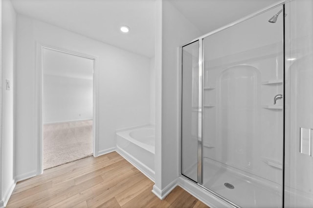 bathroom with plus walk in shower and wood-type flooring