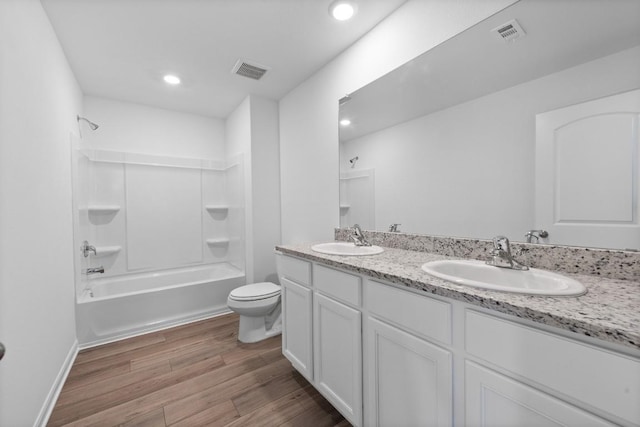 full bathroom with vanity, hardwood / wood-style flooring, toilet, and washtub / shower combination