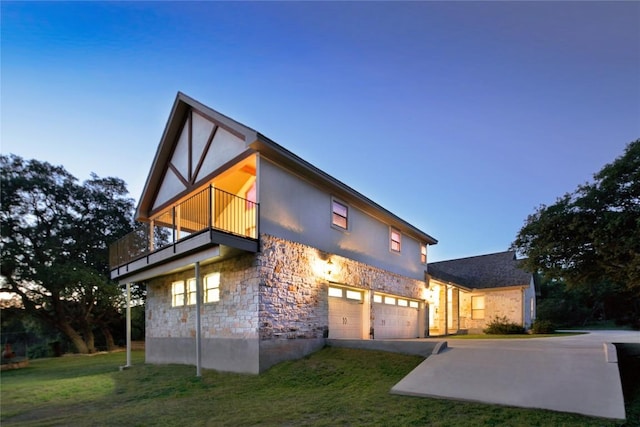 view of front of home featuring a garage, a balcony, and a front yard