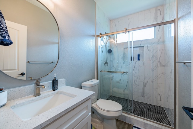 bathroom featuring vanity, toilet, and a shower with shower door