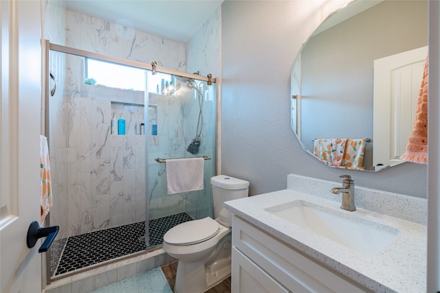 bathroom featuring vanity, an enclosed shower, and toilet