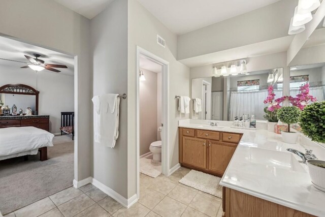 bathroom with ceiling fan, vanity, toilet, and tile patterned flooring