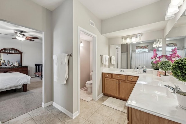 bathroom with tile patterned flooring, vanity, ceiling fan, and toilet