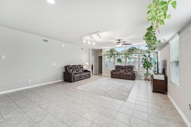 unfurnished living room with ceiling fan, rail lighting, and light tile patterned floors