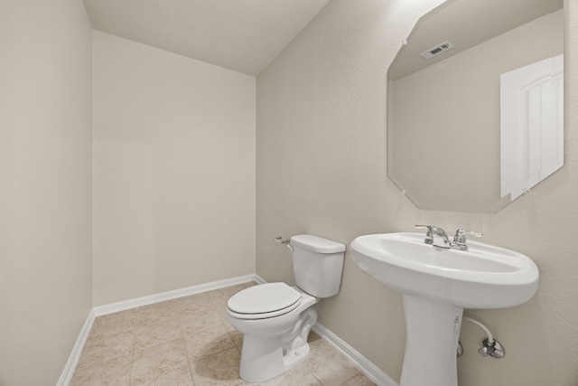 bathroom with toilet and tile patterned flooring