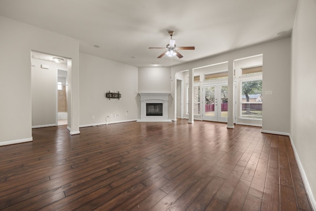 unfurnished living room with dark hardwood / wood-style floors, ceiling fan, and french doors