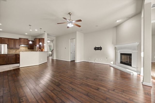 unfurnished living room with dark wood-type flooring and ceiling fan