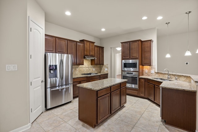 kitchen featuring appliances with stainless steel finishes, sink, hanging light fixtures, kitchen peninsula, and light stone countertops