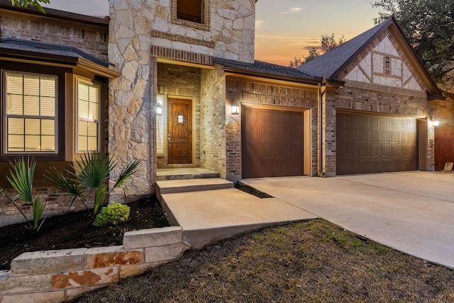 exterior entry at dusk featuring a garage