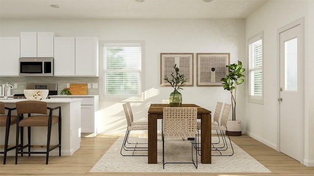 dining room with sink and light hardwood / wood-style flooring