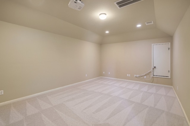 carpeted empty room with lofted ceiling